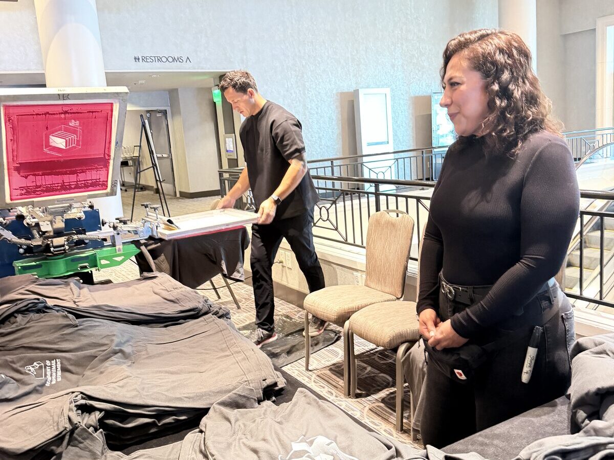 Freshly printed shirts staged on tables at a hotel mezzanine onsite printing deployment